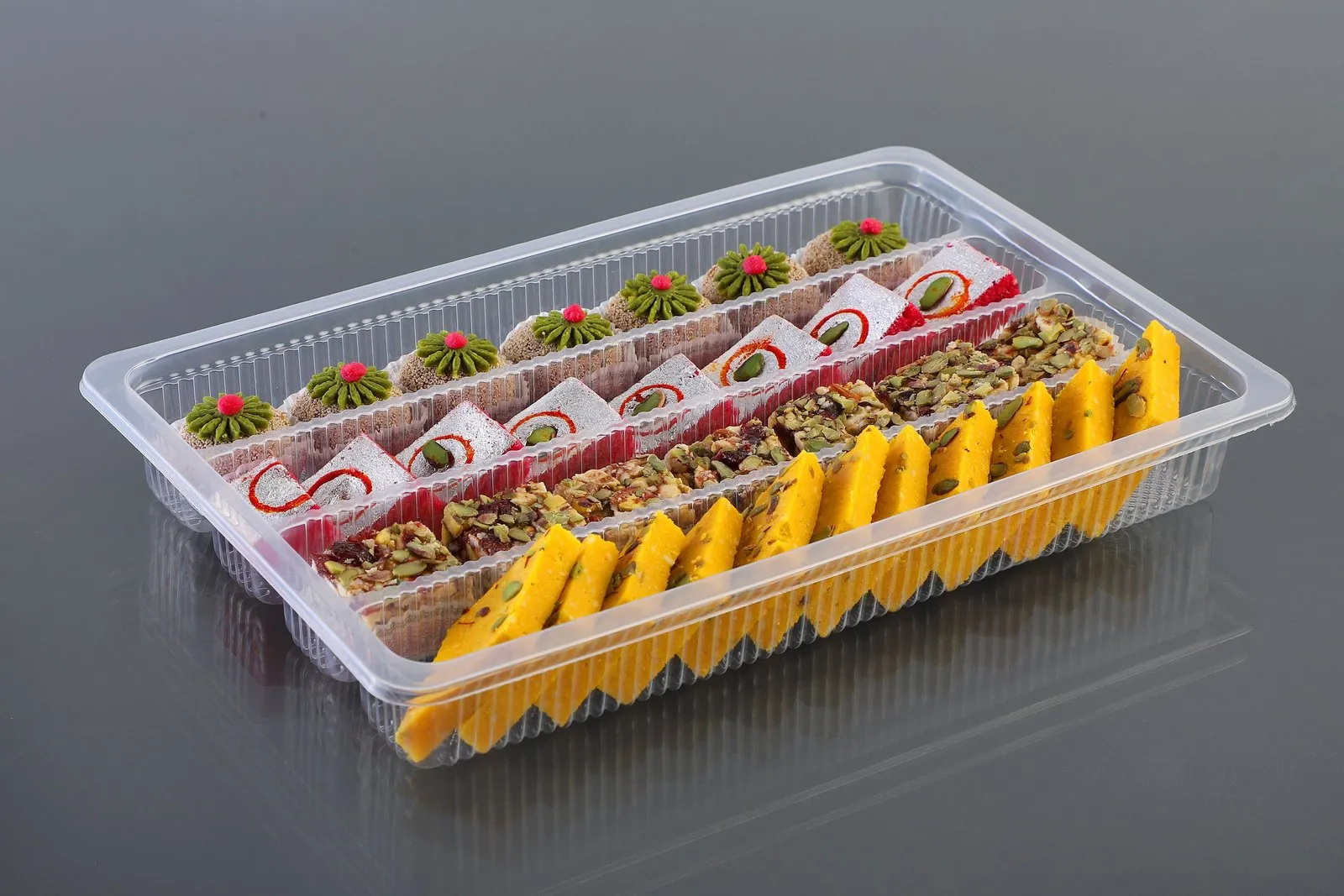 Oracle rectangular PP tray with lid, filled with an assortment of Indian sweets